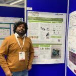 Nageshvar standing next to his poster presentation.