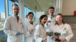 Five young people in lab coats pose with their equipment.