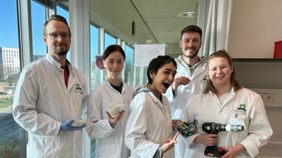 Five young people in lab coats pose with their equipment. YR at Wageningen_2023_featured_v2