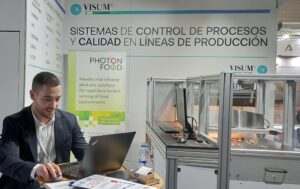 Young man at laptop at a trade fair booth